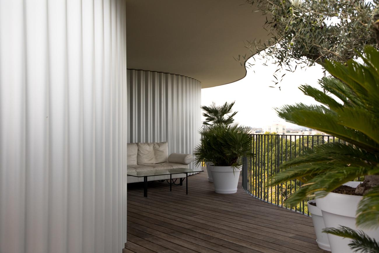 Balcony with curving walls and potted plants