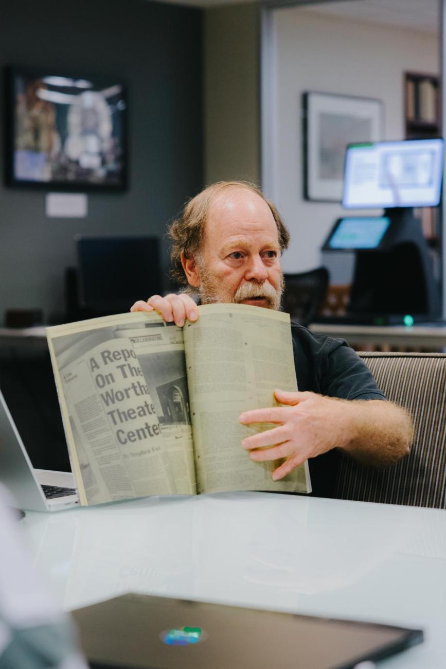 Danny Samuels holding up and open an old issue of Cite