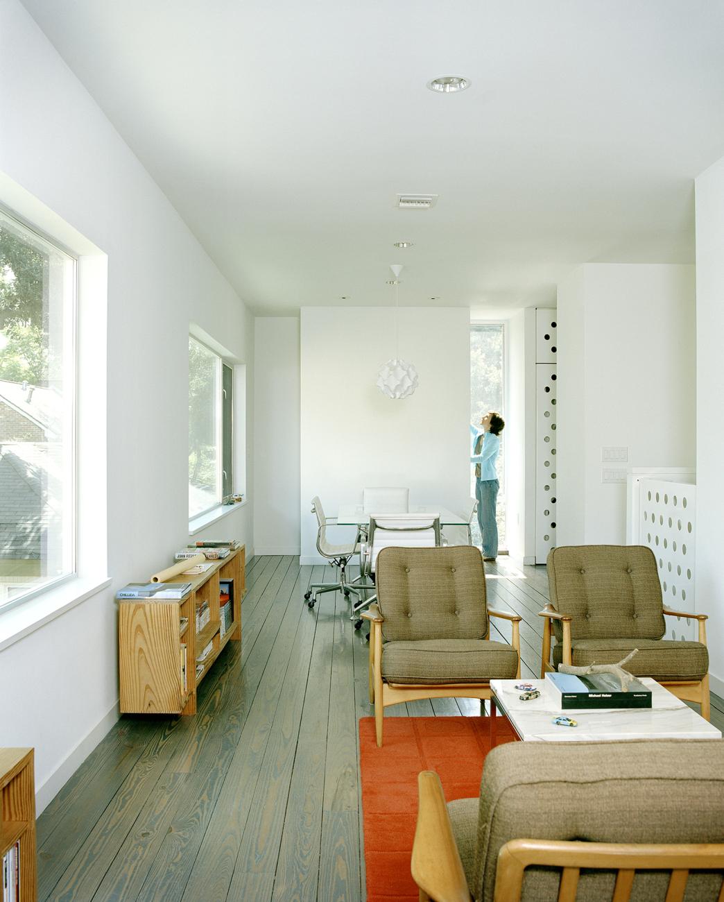 Second level living and dining areas with custom brake-form perforated steel guard rail and doors beyond